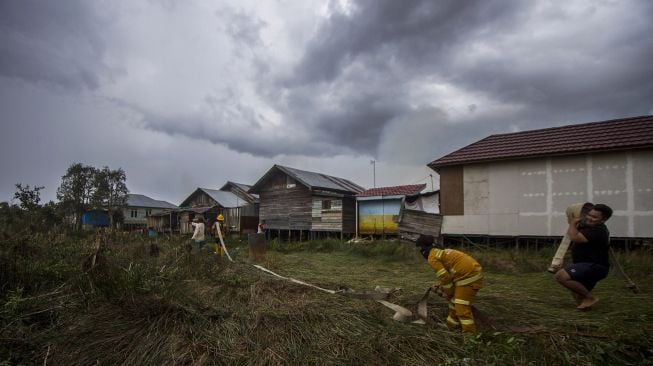 Sejumlah relawan berupaya memadamkan kebakaran lahan di Kecamatan Liang Anggang, Banjarbaru, Kalimantan Selatan, Selasa (21/9/2021).  ANTARA FOTO/Bayu Pratama S