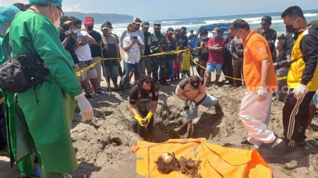 Polisi dan petugas medis melakukan proses evakuasi dan olah tempat kejadian perkara (TKP) penemuan kerangka manusia di Pantai Parangkusumo, Kretek, Bantul pada Selasa (21/9/2021) pagi. - (SuaraJogja.id/Rahmat Jiwandono)