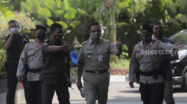 Gubernur DKI Jakarta Anies Baswedan (ketiga kanan) berjalan setibanya di Gedung Merah Putih KPK, Jakarta, Selasa (21/9/2021). [Suara.com/Angga Budhiyanto]