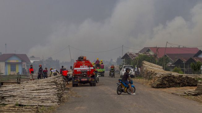 Sejumlah relawan berupaya memadamkan kebakaran lahan di Kecamatan Liang Anggang, Banjarbaru, Kalimantan Selatan, Selasa (21/9/2021).  ANTARA FOTO/Bayu Pratama S