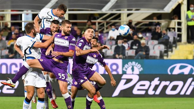 Penyerang Inter Milan Edin Dzeko (kiri) menyundul bola dan mencetak gol selama pertandingan sepak bola Serie A Italia antara Fiorentina melawan Inter Milan di Stadion Artemio Franchi di Florence, Rabu (22/9) dini hari WIB. ANDREAS SOLARO / AFP