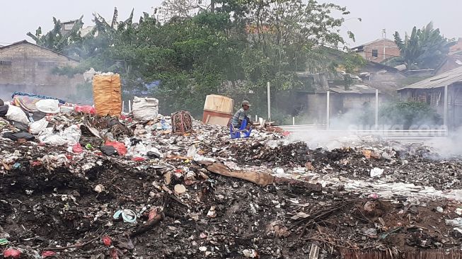 Tumpukan sampah dibakar di TPS Jalan Wijaya Kusuma Ujung X Gang Sawo 1 RT 13 RW 1 Kelurahan Pondok Betung, Pondok Aren, Kota Tangerang Selatan, Selasa (21/9/2021). [SuaraJakarta.id/Wivy Hikmatullah]