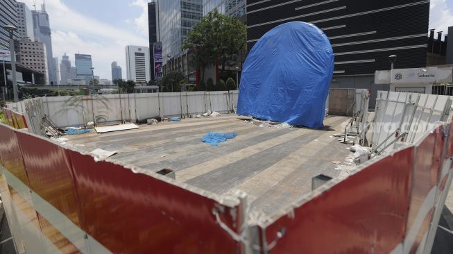 Proyek pembangunan tugu sepeda di jalur pedestrian Jalan Jenderal Sudirman, Jakarta, Rabu (22/9/2021). [Suara.com/Angga Budhiyanto]