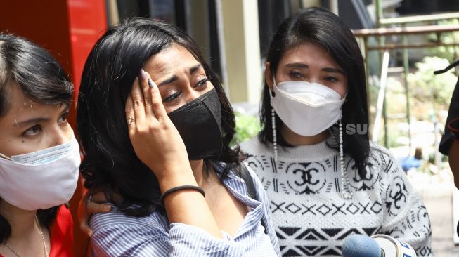 Penyanyi Karen Pooroe menangis ketika menjawab pertanyaan awak media perihal mengenai anaknya  di Polres Metro Jakarta Selatan, Rabu (22/9/2021). [Suara.com/Alfian Winanto]