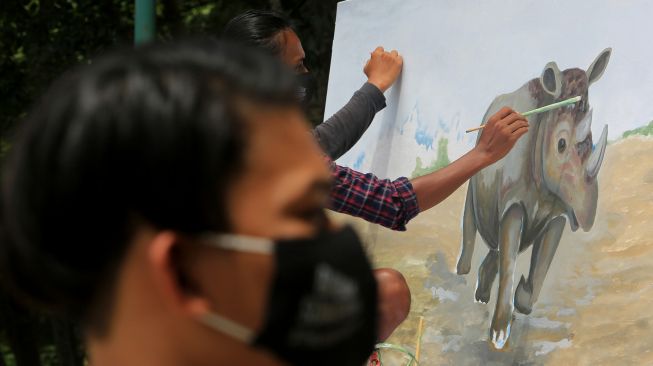 Perajin membuat lukisan atau mural badak sumatera saat kegiatan kampanye kreatif memperingati hari badak sedunia di Taman Ratu Safiatuddin, Banda Aceh, Aceh, Rabu (22/9/2021). ANTARA FOTO/Syifa Yulinnas
