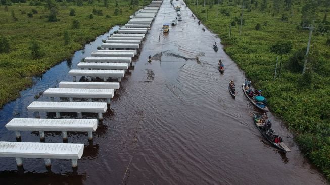 Foto udara pengendara mobil berusaha menerobos banjir yang merendam di jalan trans Kalimantan Bukit Rawi, Pulang Pisau, Kalimantan Tengah, Kamis (23/9/2021).  ANTARA FOTO/Makna Zaezar