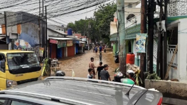 Luapan air dari Kali Licin menggenangi Jalan Raya Sawangan, Kecamatan Pancoran Mas, Depok, Kamis (23/9/2021). [Suarabogor.id/Immawan]