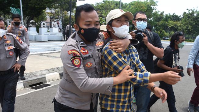 Polisi mengamankan demonstran dari Front Perjuangan Rakyat saat melakukan aksi tolak monopoli tanah dan pangan di depan Istana Negara, Jakarta, Kamis (23/9/2021).  ANTARA FOTO/Indrianto Eko Suwarso