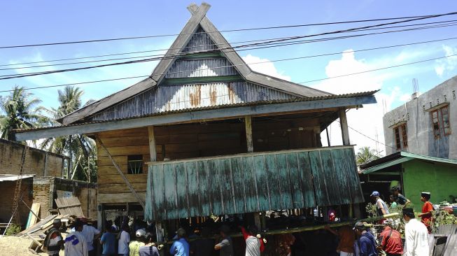 Warga bergotong royong memindahkan rumah panggung di Desa Bunde, Mamuju, Sulawesi Barat, Jumat (24/9/2021). [ANTARA FOTO/ Akbar Tado]