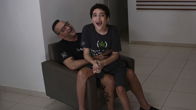 Gabriel Guerra (kanan) bersama ayahnya, Ricardo Guerra berpose di Rio de Janeiro, Brasil, pada (20/9/2021). [Carl de Souza / AFP]