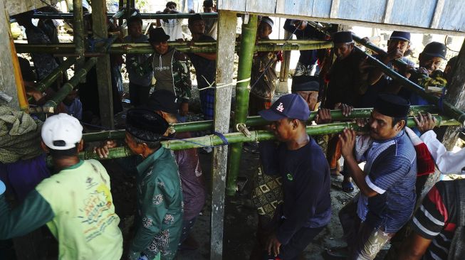 Warga bergotong royong memindahkan rumah panggung di Desa Bunde, Mamuju, Sulawesi Barat, Jumat (24/9/2021). [ANTARA FOTO/ Akbar Tado]