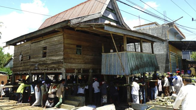 Warga bergotong royong memindahkan rumah panggung di Desa Bunde, Mamuju, Sulawesi Barat, Jumat (24/9/2021). [ANTARA FOTO/ Akbar Tado]