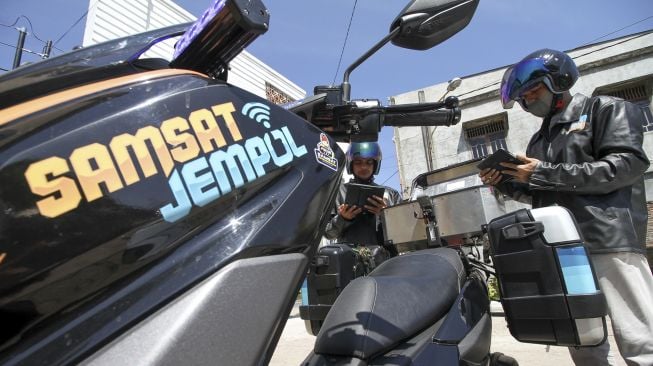 Petugas Samsat bersiap melayani pembayaran pajak kendaraan warga melalui fasilitas sepeda motor Sijempol di Desa Panggoi, Lhokseumawe, Aceh, Jumat (24/9/2021). [ANTARA FOTO/Rahmad]