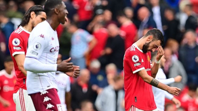 Gelandang Manchester United Bruno Fernandes bereaksi setelah gagal mencetak gol dari titik penalti selama pertandingan sepak bola Liga Premier Inggris antara Manchester United melawan Aston Villa di Old Trafford, Manchester, Inggris, Sabtu (25/9). Paul ELLIS / AFP