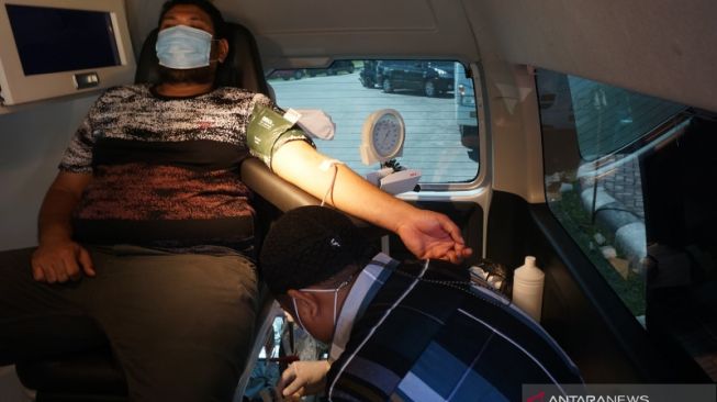 Seorang warga mendonorkan darahnya di dalam mobil pelayanan keliling di kompleks Center Point, Suwawa, Kabupaten Bone Bolango, Gorontalo [ANTARA/Adiwinata Solihin] 