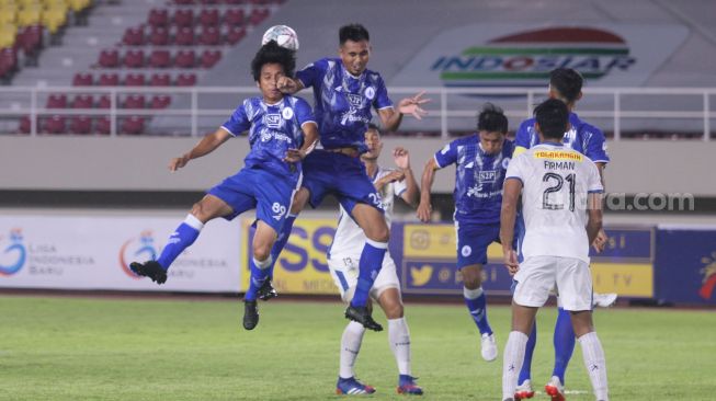 Pemain PSIM Yogyakarta dan PSCS Cilacap berduel udara dalam pertandingan Liga 2 Grup C di Stadion Manahan, Solo, Minggu (26/9/2021). [Suara.com/Ronald Seger Prabowo]