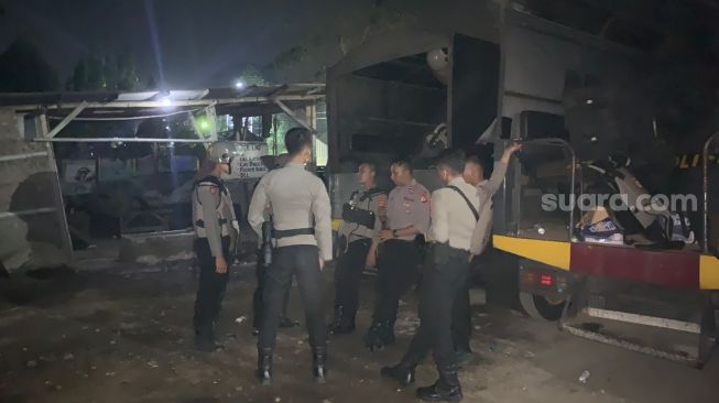 Ratusan personel Polres Cianjur berjaga di lokasi kejadian pasca bentrokan antar ormas PP dan BPPKB di perbatasan Cianjur-Sukabumi, Minggu (26/9/2021) malam. [SuaraBogor.id-Suara.com/Fauzi Noviandi]