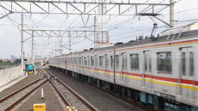 Kereta Commuterline melintas di Jalur Layang Bogor Line Stasiun Manggarai, Jakarta Selatan, Minggu (26/9/2021). [Suara.com/Alfian Winanto]