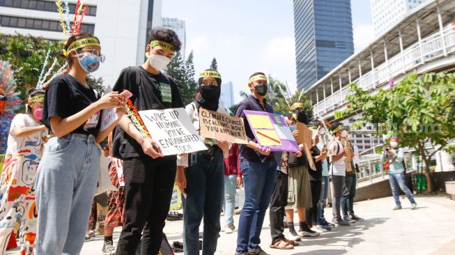 Sejumlah aktivis melakukan aksi protes terkait perubahan iklim di Kawasan Dukuh Atas, Jakarta Pusat, Minggu (26/9/2021). [Suara.com/Alfian Winanto]