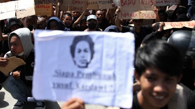 Sejumlah mahasiswa memegang poster di depan personel Polda Sulawesi Tenggara saat aksi September berdarah berujung bentrok di depan Markas Polda Sulawesi Tenggara, Kendari, Sulawesi Tenggara, Senin (27/9/2021). ANTARA FOTO/Jojon