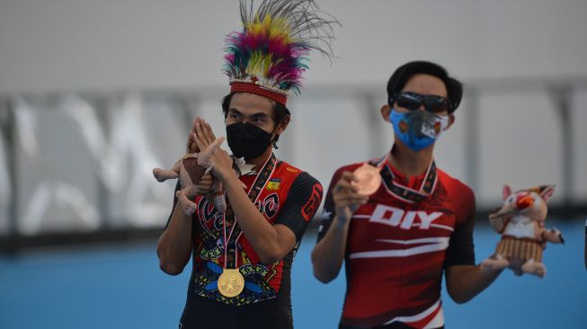 Atlet sepatu roda putra Papua Jeremia Wihardja (kiri) dan atlet asal D.I Yogyakarta Hilmanafika Sagarmatha berpose dengan medalinya usai final nomor 400 meter individual time trial (ITT) putra PON Papua di Arena Klemen Tinal Roller Sport, Kota Jayapura, Papua, Senin (27/9/2021).  ANTARA FOTO/Fauzan