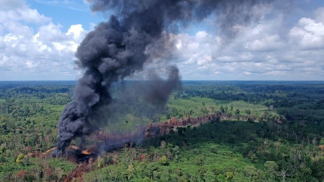 Asap mengepul dari sumur minyak ilegal yang terbakar di Bungku, Bajubang, Batanghari, Jambi, Senin (27/9/2021). ANTARA FOTO/Wahdi Septiawan