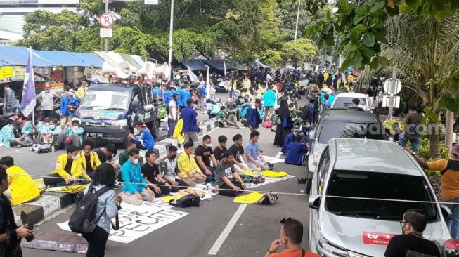 Sejumlah mahasiswa dari BEM SI menunaikan salat Dzuhur berjamaah di sela aksi menuntut menuntut pembatalan pemecatan 57 pegawai KPK di Kuningan, Jakarta Pusat, Senin (27/9/2021). [Suara.com/Yaumal Asri Adi Hutasuhut]