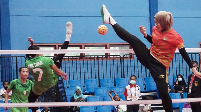 Atlet sepak takraw putri Riau Nurhidayah (kanan) menangkis smes dari atlet sepak takraw putri Jawa Timur Avlia Febriani (tengah) dalam pertandingan sepak takraw ganda putri PON Papua di GOR Trikora Universitas Cenderawasih, Jayapura, Papua, Senin (27/9/2021).  ANTARA FOTO/Indrayadi TH