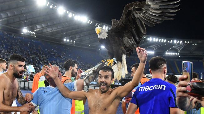 Para pemain Lazio merayakan akhir pertandingan sepak bola Serie A Italia Lazio melawan AS Roma  di Stadion Olimpico, Senin (27/9/2021) dini hari WIB.  Vincenzo PINTO / AFP