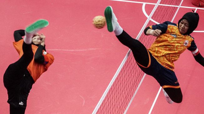 Atlet sepak takraw DKI Jakarta Alda Aulia (kanani) berupaya menahan bola yang dilepaskan atlet sepak takraw Sulawesi Selatan Madiana (kiri) dalam pertandingan sepak takraw ganda putri PON Papua di GOR Trikora Universitas Cenderawasih, Jayapura, Papua, Selasa (28/9/2021).  ANTARA FOTO
