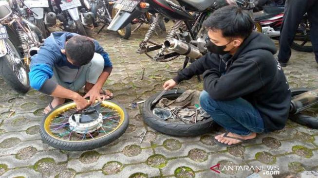 Dua warga saat sedang mengganti knalpot kendaraannya dengan standar di Kantor Satlantas Polres Kranganyar, Selasa (28/9/2021) [ANTARA/HO-Humas Polres Karanganyar].