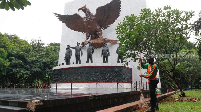 Petugas membersihkan area Tugu Pahlawan Revolusi di Monumen Pancasila Sakti, Lubang Buaya, Jakarta Timur, Selasa (28/9/2021). [Suara.com/Alfian Winanto]