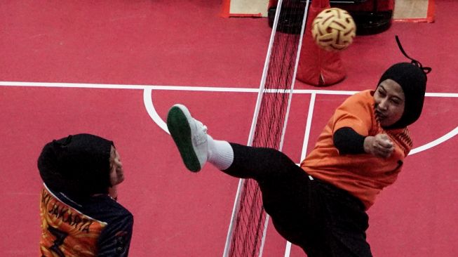 Atlet sepak takraw Sulawesi Selatan Sri Wahyuni (kanan) gagal menepis bola dari atlet sepak takraw DKI Jakarta Alda Aulia (kiri) dalam pertandingan sepak takraw ganda putri PON Papua di GOR Trikora Universitas Cenderawasih, Jayapura, Papua, Selasa (28/9/2021). ANTARA FOTO