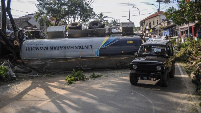 Kendaraan melintas di samping truk yang mengalami kecelakaan tunggal di Nagreg, Kabupaten Bandung, Jawa Barat, Selasa (28/9/2021).   ANTARA FOTO/Raisan Al Farisi