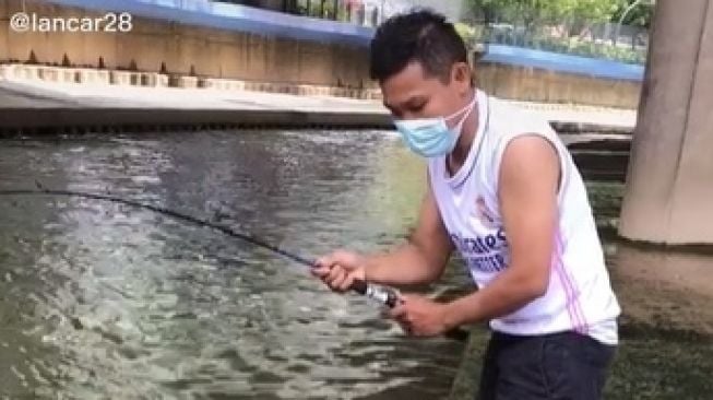 Viral Cowok Asyik Mancing Di Bawah Jembatan Dapat Anak Buaya. (TikTok)