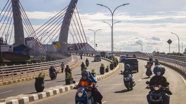 Sejumlah pengendara motor melintas di bawah Jembatan Sungai Alalak, Banjarmasin, Kalimantan Selatan, Rabu (29/9/2021).  ANTARA FOTO/Bayu Pratama 
