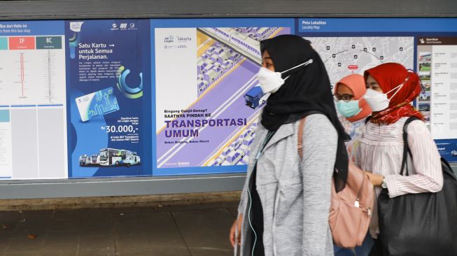 Warga melintas di Halte Stasiun Palmerah, Jakarta Pusat, Kamis (30/9/2021). [Suara.com/Alfian Winanto]