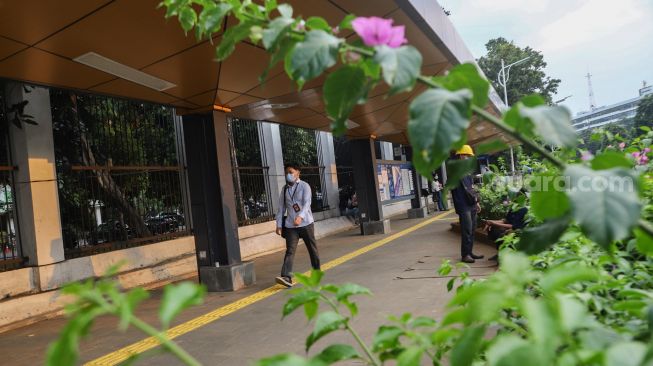 Warga melintas di Halte Stasiun Palmerah, Jakarta Pusat, Kamis (30/9/2021). [Suara.com/Alfian Winanto]