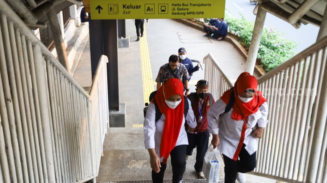 Warga melintas di Halte Stasiun Palmerah, Jakarta Pusat Kamis (30/9/2021). [Suara.com/Alfian Winanto]