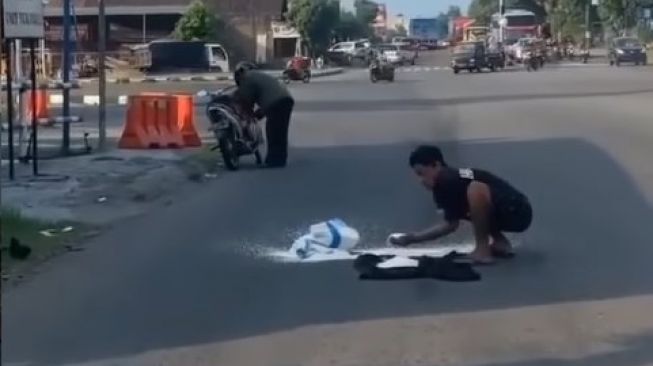 Sebuah video yang memperlihatkan dua pria memungut beras milik pengendara motor yang terjatuh viral di media sosial. [tangkapan layar Instagram/@banyuwangi_hitss]