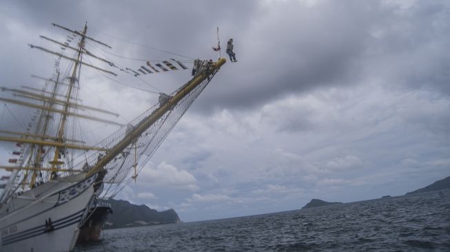 Perwira KRI Bima Suci melompat dari ujung haluan (cocor) saat tradisi "terjun ke laut" bagi personel KRI Bima Suci yang naik pangkat di Dermaga Faslabuh Selat Lampa Pangkalan TNI AL Ranai, Natuna, Kepulauan Riau, Jumat (1/10/2021). ANTARA FOTO/Muhammad Adimaja