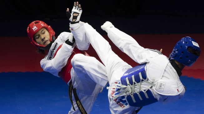 Atlet taekwondo Jambi Farel Fatra (kanan) melepaskan tendangan ke arah atlet DKI Jakarta M Bassam (kiri) dalam final Kyorugi kelas -58 kg putra PON XX Papua 2021 di GOR Politeknik Penerbangan Kayu Batu, Kota Jayapura, Papua, Jumat (1/10). [ANTARA FOTO/Nova Wahyudi]