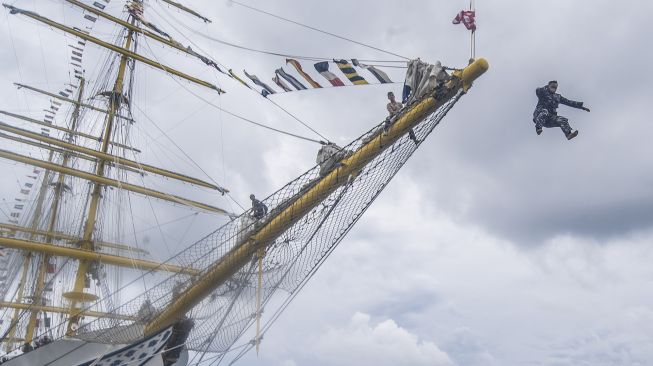 Perwira KRI Bima Suci melompat dari ujung haluan (cocor) saat tradisi "terjun ke laut" bagi personel KRI Bima Suci yang naik pangkat di Dermaga Faslabuh Selat Lampa Pangkalan TNI AL Ranai, Natuna, Kepulauan Riau, Jumat (1/10/2021). ANTARA FOTO/Muhammad Adimaja