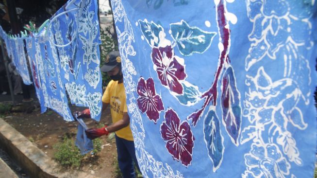 Perajin menjemur kain batik buatan peserta di kampung batik Cibuluh, Kota Bogor, Jawa Barat, Sabtu (2/20/2021). [ANTARA FOTO/Arif Firmansyah]