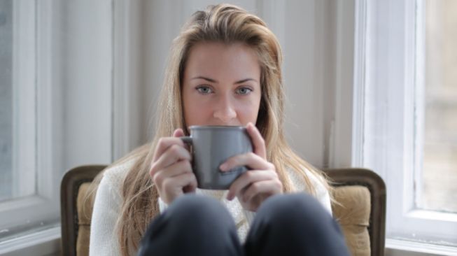 Ilustrasi wanita sedang meminum kopi. (pexels.com/Andrea Piacquadio)