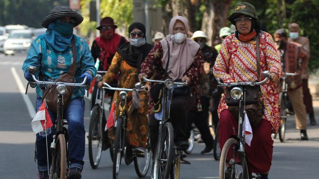 Anggota komunitas sepeda tua Senopati berpakaian batik mengayuh sepedanya di Jalan Darmo, Surabaya, Jawa Timur, Minggu (3/10/2021). ANTARA FOTO/Didik Suhartono