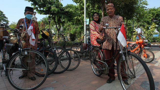 Anggota komunitas sepeda tua Senopati berpakaian batik bersiap mengayuh sepedanya di Jalan Darmo, Surabaya, Jawa Timur, Minggu (3/10/2021). ANTARA FOTO/Didik Suhartono