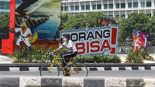 Warga berolahraga di kawasan Bundaran Hotel Indonesia (HI), Jakarta Pusat, Minggu (3/10/2021). [Suara.com/Alfian Winanto]