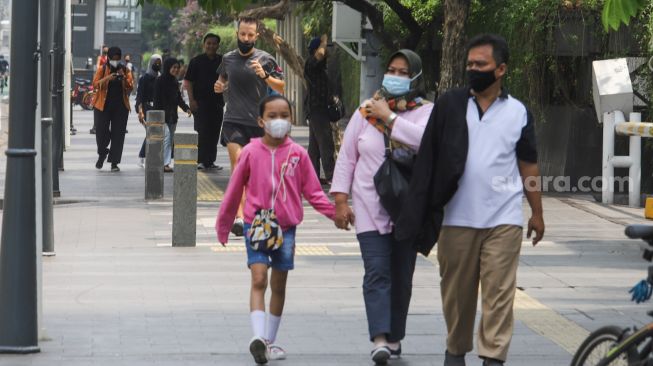 Warga berolahraga di Jalan Jenderal Sudirman, Jakarta Pusat, Minggu (3/10/2021). [Suara.com/Alfian Winanto]