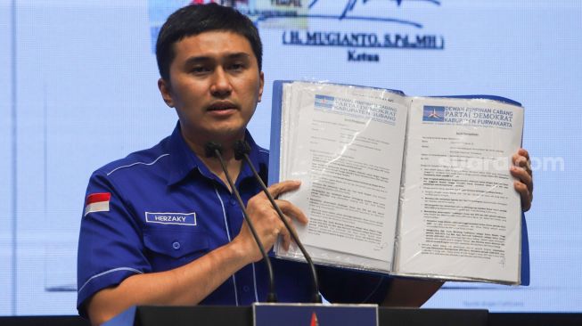 Kepala Badan Komunikasi Strategis DPP Partai Demokrat Herzaky Mahendra Putra menunjukkan bukti surat hasil dukungan kongres kubu AHY saat menggelar konferensi pers di Kantor DPP Partai Demokrat, Menteng, Jakarta Pusat, Minggu (3/10/2021). [Suara.com/Alfian Winanto]